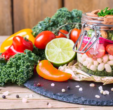 a mason jar of beans and vegetables on a table