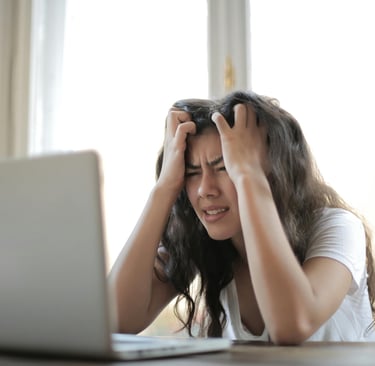 a woman sitting at a table with a laptop computer