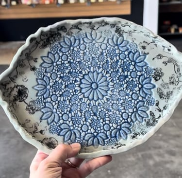 an eye shaped plate with a lace texture in blues and pale blue glaze