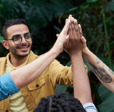 a group of people giving each other a high five, persone che si supportano dandosi una mano