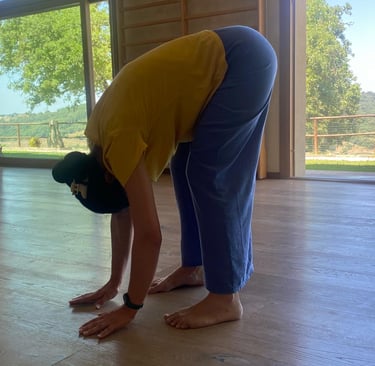 a man in a yellow shirt is bending over his head, bend over, classe di bioenergetica