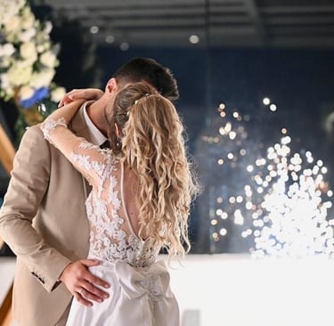 Stage fireworks bursting as the couple shares their first dance in a romantic setting.