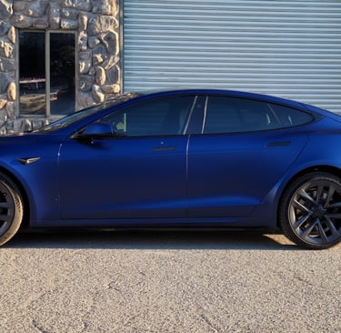 Satin PPF wrap on a blue Tesla MS with dark tint, expertly installed in the shop.