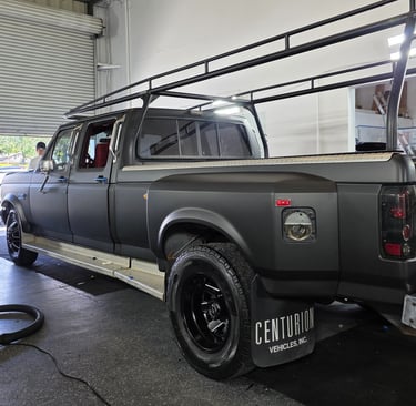 black matte vinyl wrap on a ford F350 with dark wheels, expertly installed in the shop.