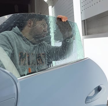Bluemax Tint Master Technician applying ceramic window film with care.