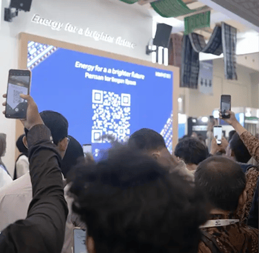 Mass crowd scanning QR code on large LED screen for simultaneous game participation at corporate gat