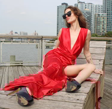 a woman in a red dress sitting on a bench