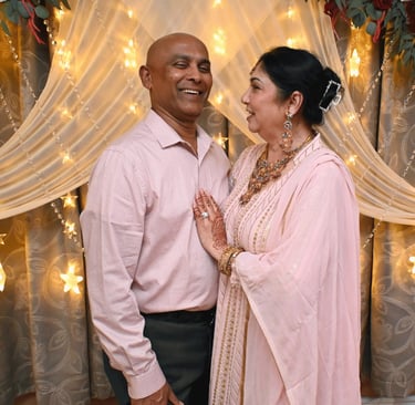 a man and woman standing in front of a curtain