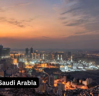 An expansive, high-angle panoramic view of Mecca, Saudi Arabia, at sunset or twilight. The Abraj Al-