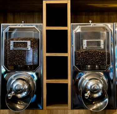 A row of coffee machines sitting on top of a wooden shelf