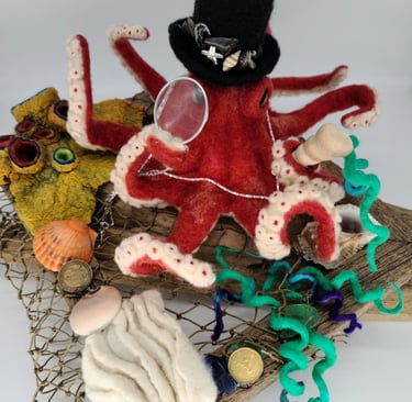 a felted octopus with a hat on a wooden board