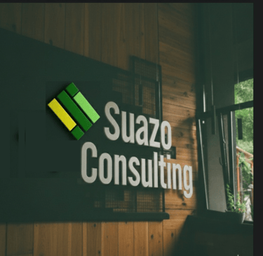Logotipo de Suazo Consulting en relieve sobre una pared de madera en una oficina con ventana.
