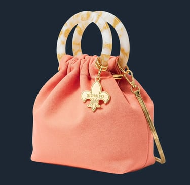 Tas kantong berwarna peach dengan gagang resin efek marmer di latar belakang putih.