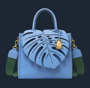 Tas jinjing biru telur asin dengan tutup berbentuk daun Monstera dan tali hijau di latar belakang putih.