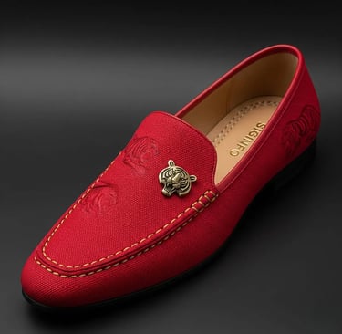 Sepatu loafer merah Signifo dengan logo kepala harimau emas.