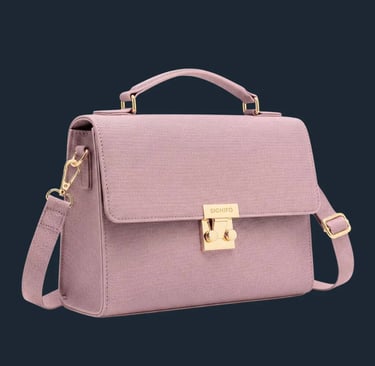 Tas satchel berwarna dusty rose mauve dengan gagang atas dan kuncian emas di latar belakang putih.