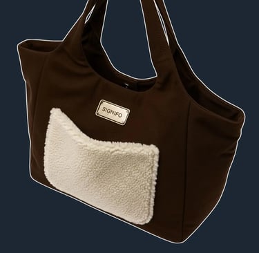 Detail tas tote SIGNIFO dengan kantong depan berbahan shearling putih yang lembut.