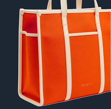 A clean, minimalist tote with a very simple, upright rectangular shape. The bag's panels are joined with prominent, external