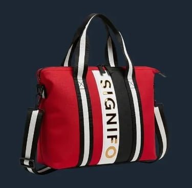 Tas travel SIGNIFO dari kanvas merah dengan aksen garis-garis hitam dan putih yang modern.