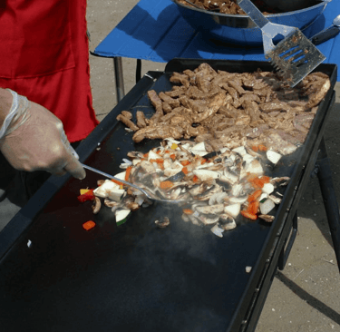 a person is cooking food on a grill