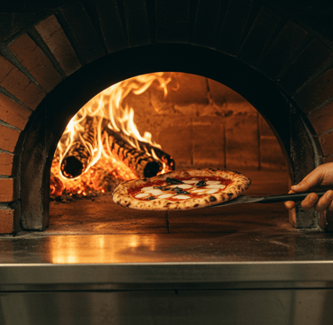 Roman pizza coming out of pizza oven