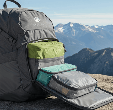 backpack showcasing packing cubes with mountain scenic background