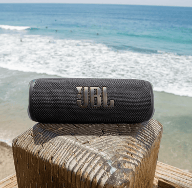 a speaker with a bluetoothed speaker on a wooden fence