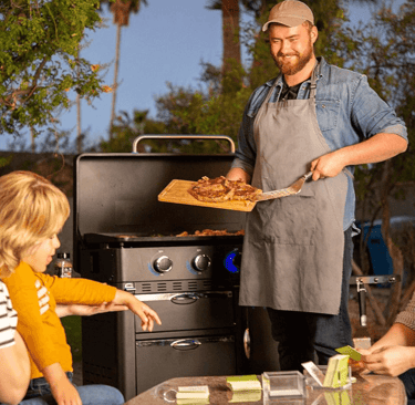 a man and woman cooking on a Pit Boss griddle
