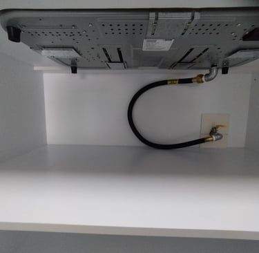 A black flexible gas pipe connecting home appliance with main gas line