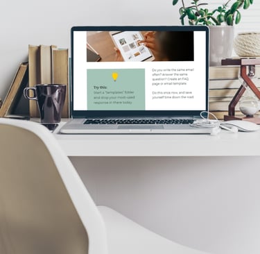 a laptop on a desk with a plant in the background and virtual assistant freebie on the screen