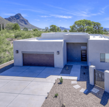 a house with a large driveway and a mountain view