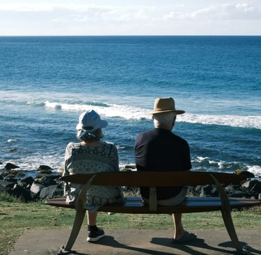 A retired couple sat on a bench looking out to sea