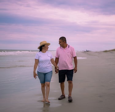 A retire couple enjoying a walk across the beach