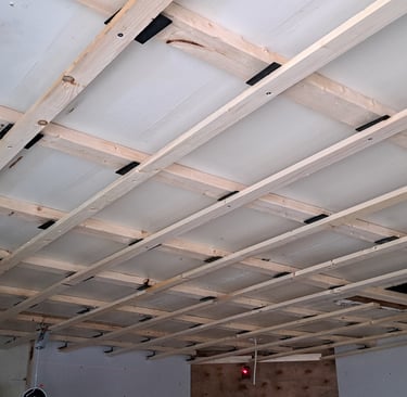Grid-style ceiling framing structure prepared for wood panel installation during interior levelled renovation project