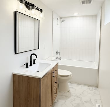 Modern bathroom featuring a wood vanity, matte black fixtures, and marble hexagon tile flooring.