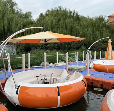 قارب دائري برتقالي مزود بمظلة كبيرة وطاولة شواء في الوسط، مخصص للجولات العائلية فوق البحيرة