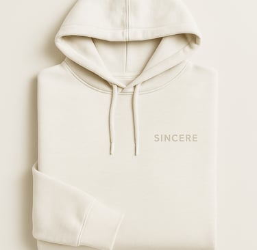 Minimalist off-white hoodie flat lay with the word SINCERE printed in small, light sans-serif font o