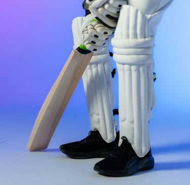 showing man's legs and hands holding cricket bat and wear pads and black running shoes