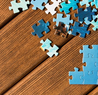 Puzzle pieces on brown floor.