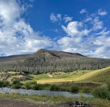 a mountain scene with a river and a mountain in the background