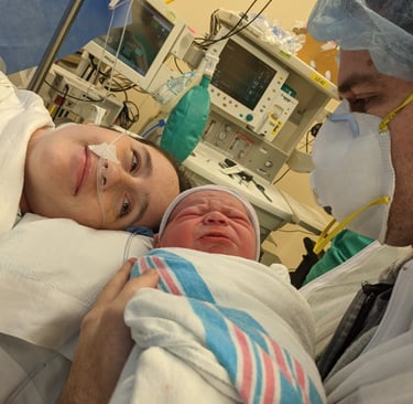 Image of mom and baby while mom is being patched up after a C-section.