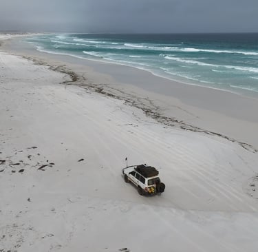 Toyota Land Cruiser 4x4 rijdend over een afgelegen strand in West Australië
