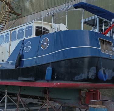 A double width canal going boat with a British ensign flag