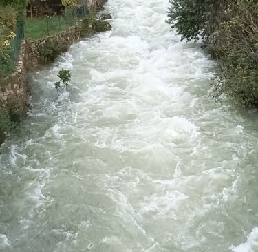 The river flows under the old bridge