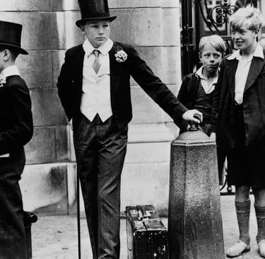 Local boys look on as two Harrow schoolboys wait outside Lord’s cricket ground