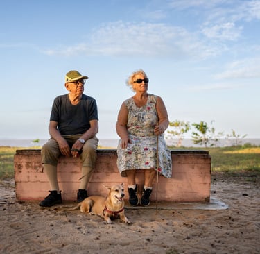 Un couple de personnes âgées et leur chien en bord de mer
