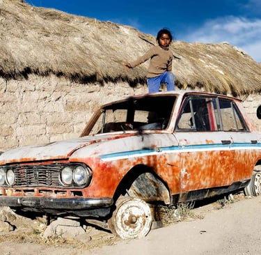 Des enfants jouent sur l'épave d'une voiture dans le salar d'Uyuni en Bolivie