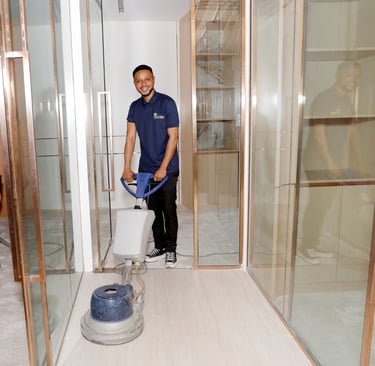 a man in a blue shirt is cleaning a floor