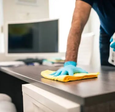 a man cleaning a desk with a sponge pad