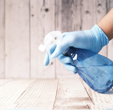 a person in gloves is cleaning a table
